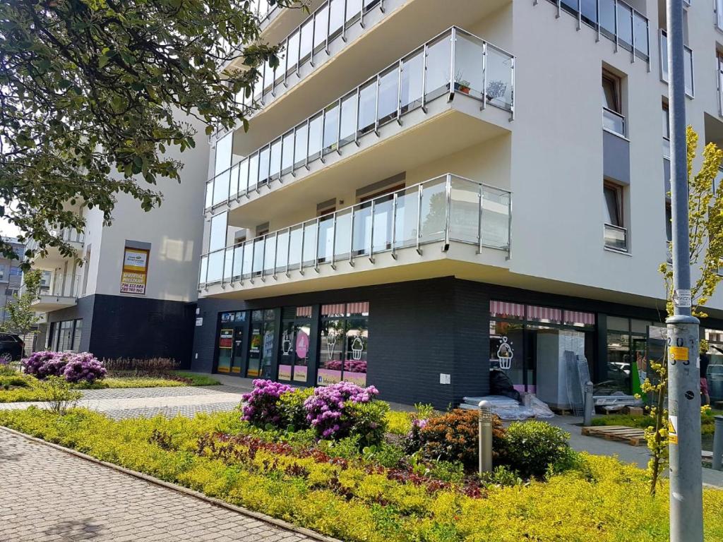 apartamentowiec z balkonem i kwiatami w obiekcie Apartamenty Sunandrelax Kołobrzeg - Apartament Słoneczny w Kołobrzegu
