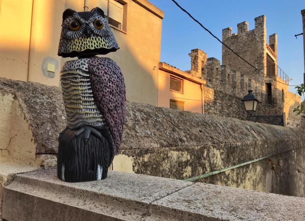 a statue of an owl sitting on a wall at Cal Pere de L'Onclet in Montblanc