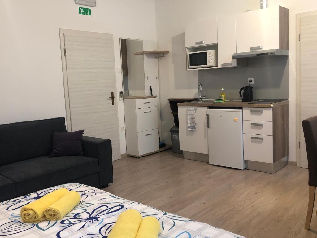 a living room with a couch and a kitchen at Apartments & Rooms Nardin in Izola