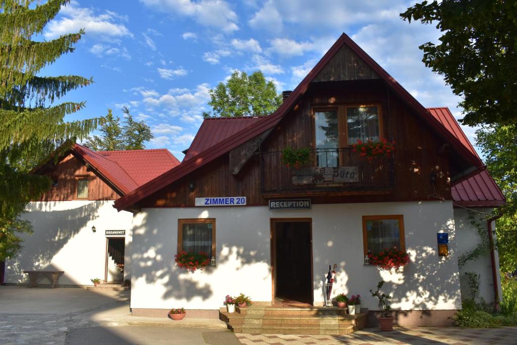 a white building with a red roof at House Boro in Jezerce