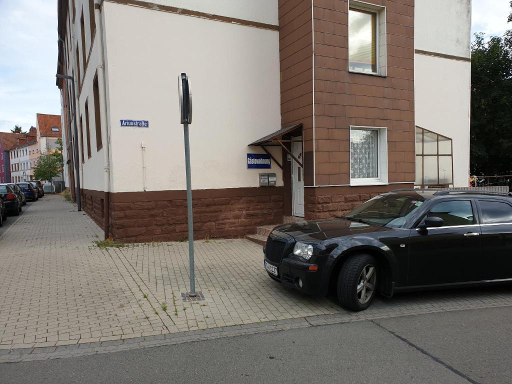 ein schwarzes Auto, das vor einem Gebäude parkt in der Unterkunft Gästewohnung in Pirmasens