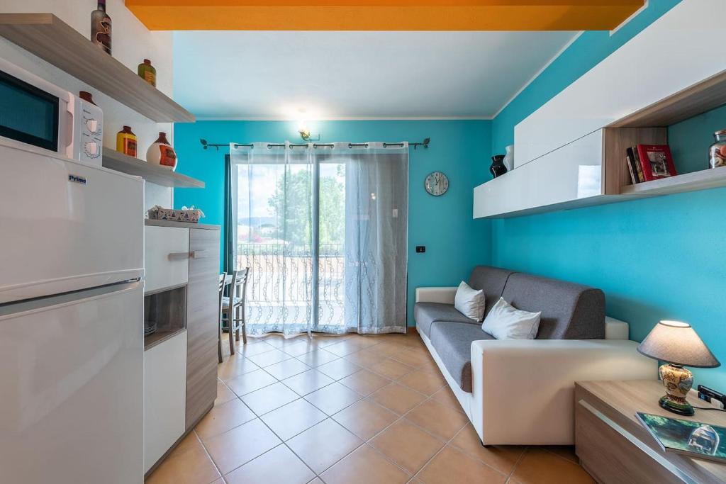 a living room with a couch and a kitchen at Pearl Coast Apartment in Santa Luria