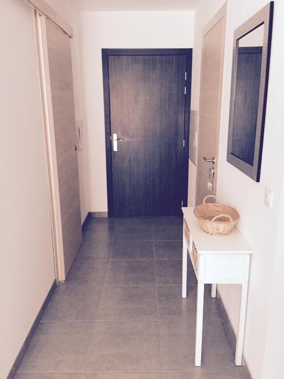 un couloir avec une porte noire et une table blanche dans l'établissement Vacances agréables..., à Bastia