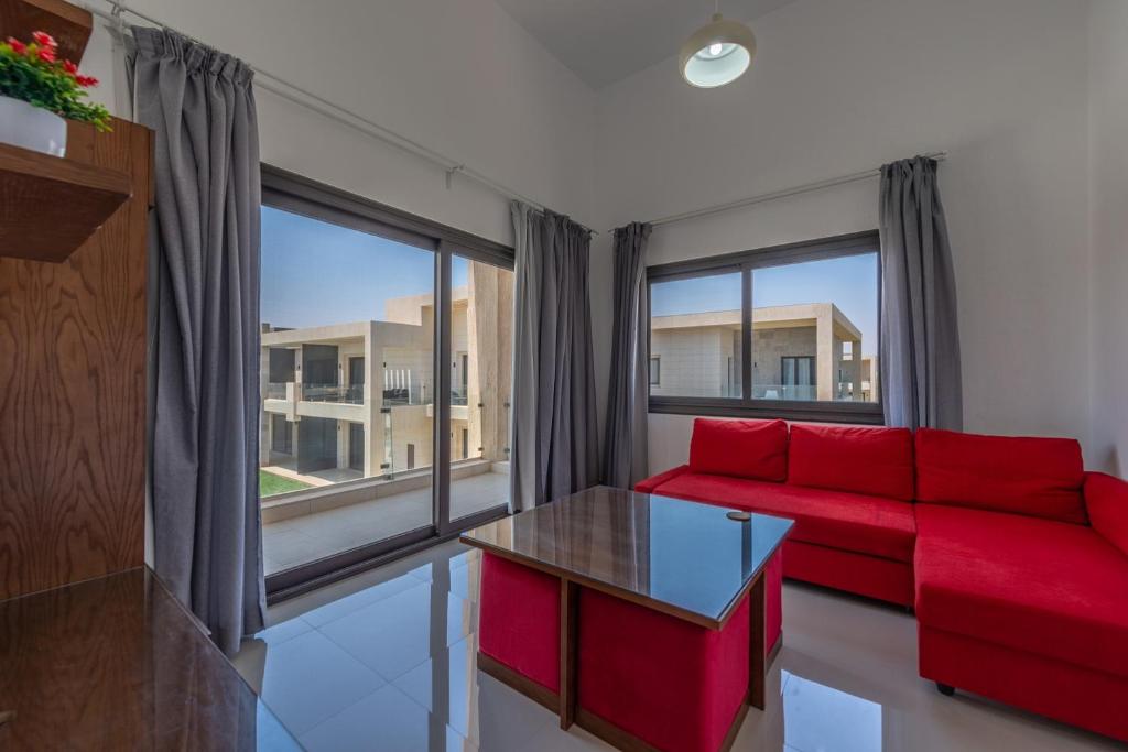 sala de estar con sofá rojo y mesa en Golden Apartments Pool View 1-Bedroom Apartment in G-Cribs, El Gouna, en Hurghada