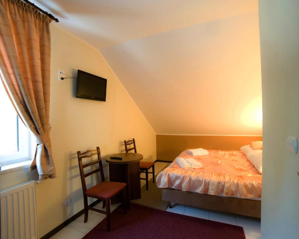 a bedroom with a bed and a table and chairs at Maciejowa Chata Stare Lubiejewo in Ostrów Mazowiecka