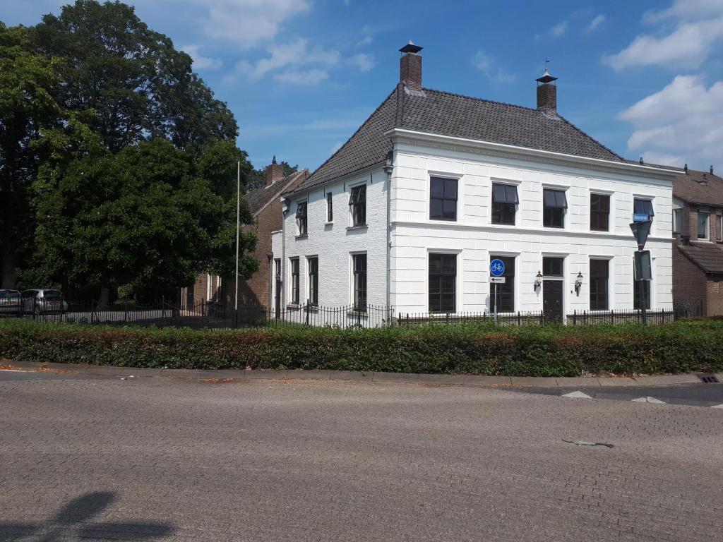 a white building with a black roof on a street at Logement 1818 in Bakel