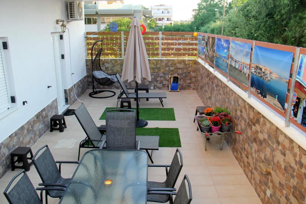 a balcony with chairs and tables and an umbrella at Chania City Home in Chania