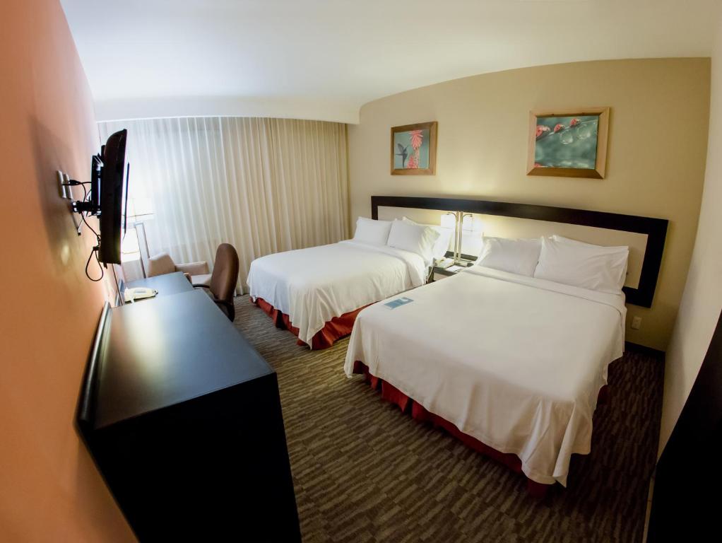 Postel nebo postele na pokoji v ubytování Excellence Express & Suites