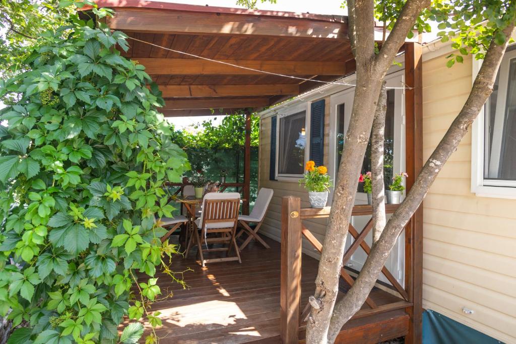 a deck with a pergola and a table and chairs at Krk Mobile Homes in Klimno
