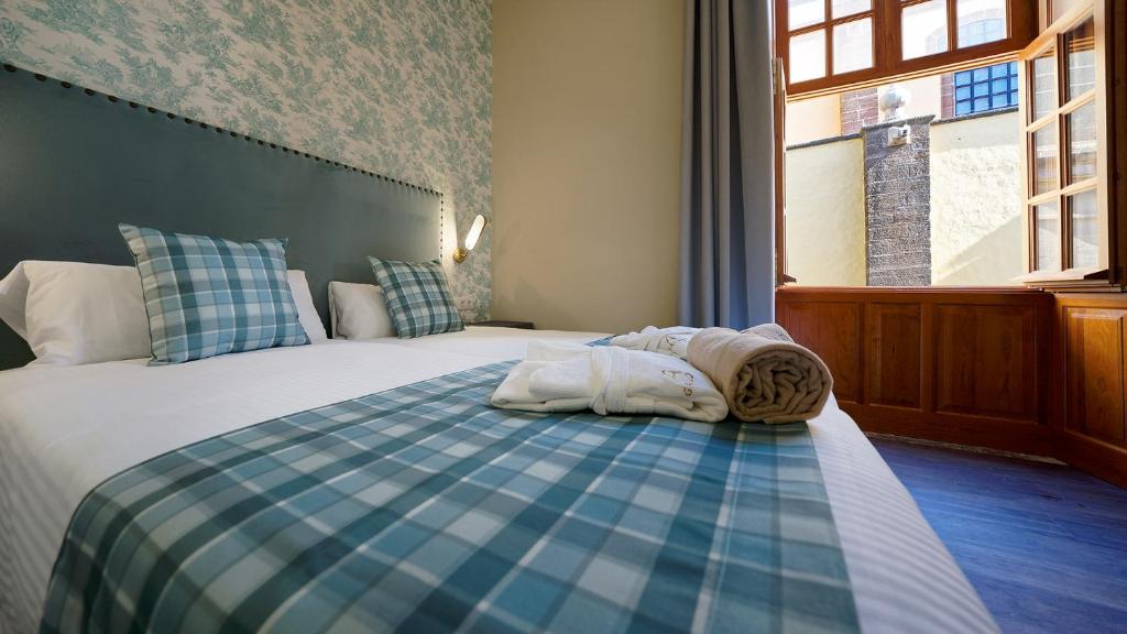 Postel nebo postele na pokoji v ubytování Hotel Emblemático Agáldar