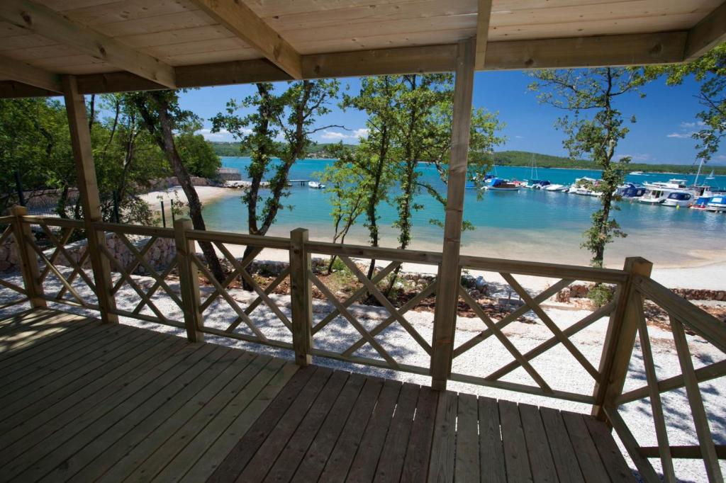 a wooden porch with a view of the beach at Krk Mobile Homes in Klimno