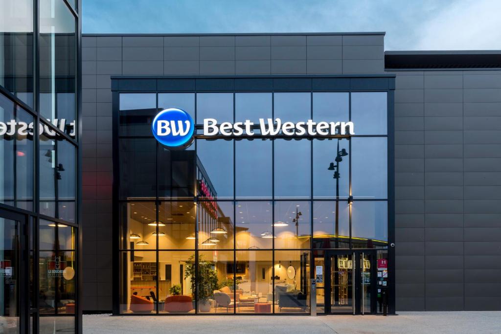 um edifício com um cartaz que diz "Compre Best Western" em BEST WESTERN HOTEL DIJON QUETIGNY em Quétigny