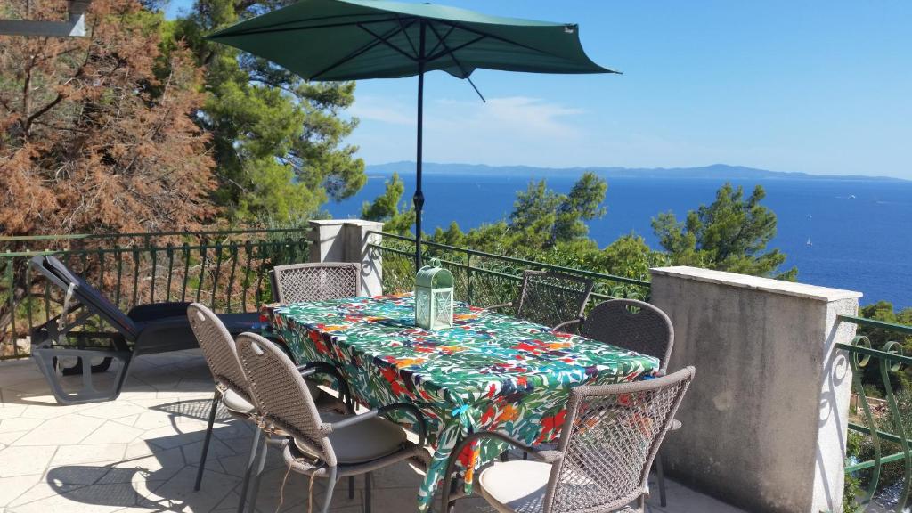 a table and chairs with an umbrella on a balcony at Apartments Vila Vino in Sveta Nedelja