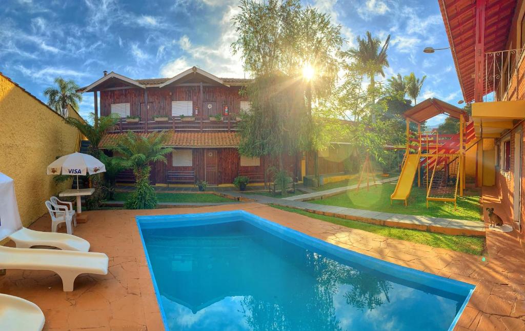 een huis met een zwembad en een speeltuin bij Pousada Canto Verde in São Bento do Sapucaí