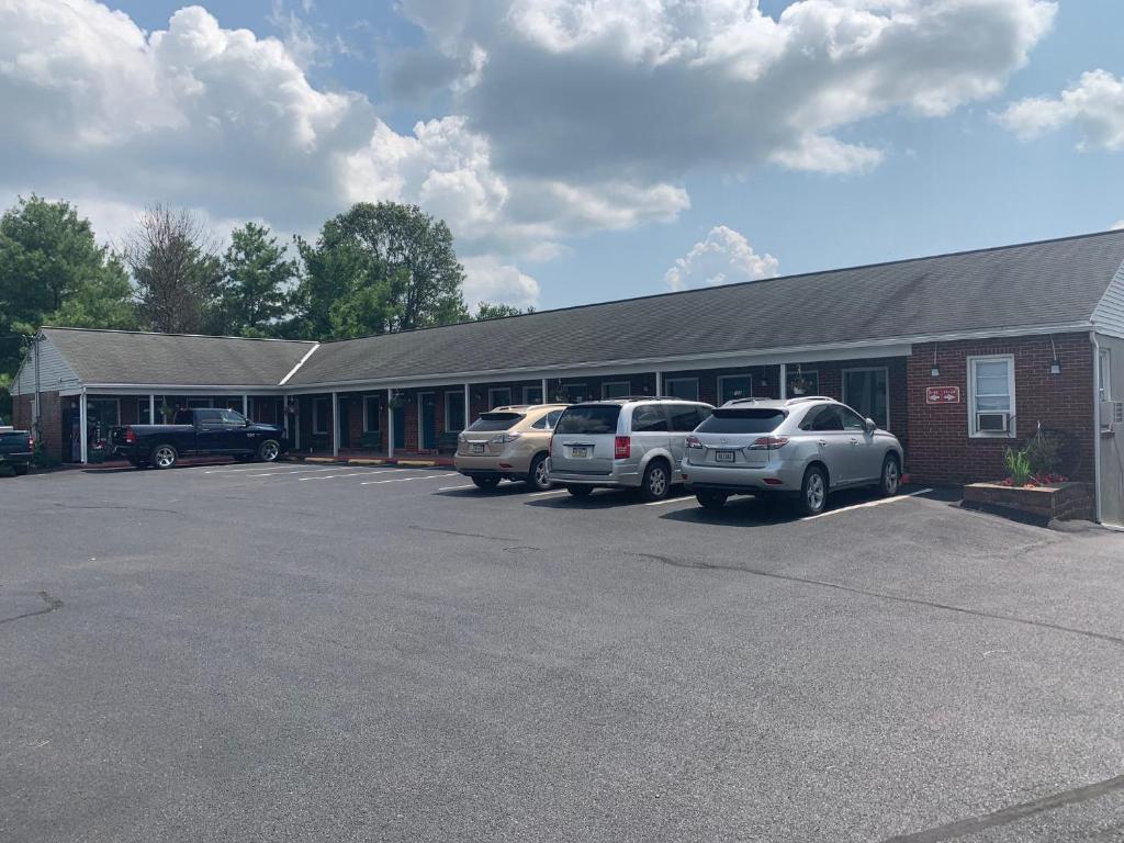 um edifício com três carros estacionados num parque de estacionamento em Mt. Vernon Motel em Manheim