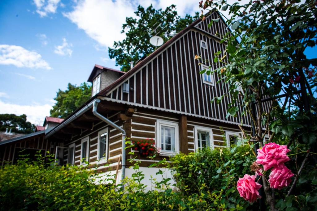 una casa de madera con flores delante en Knežicka chalupa en Vrchlabí