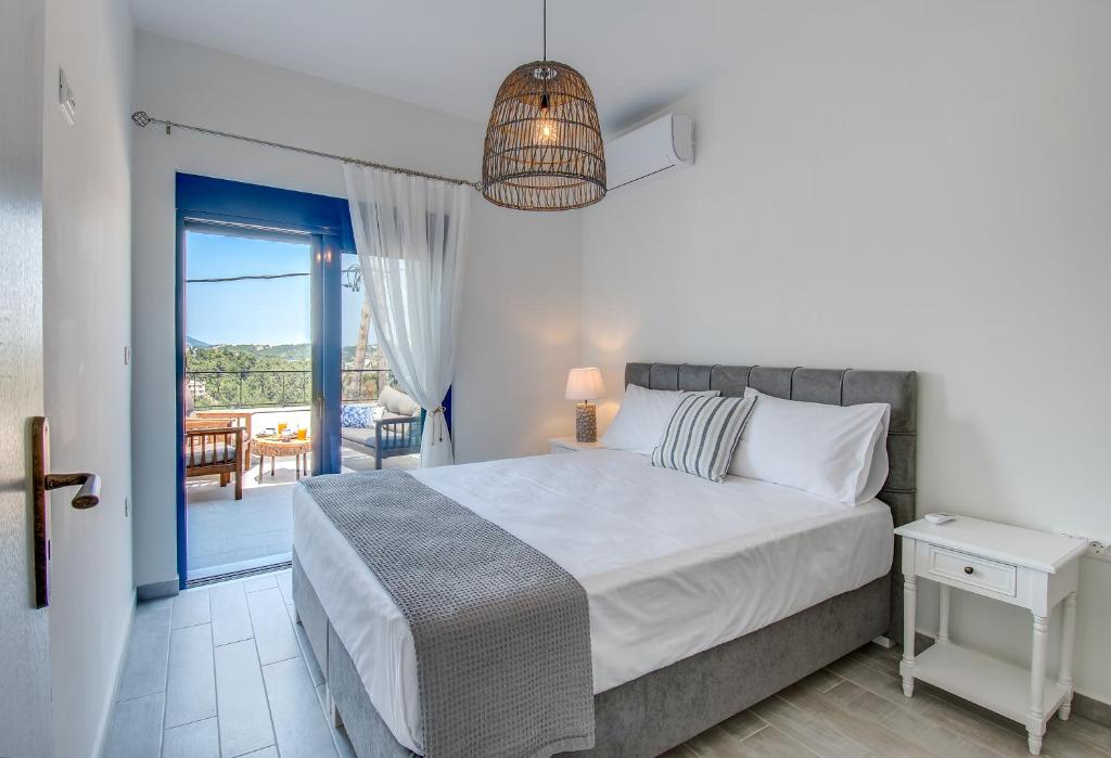 une chambre avec un lit et un balcon dans l'établissement Villa Akrochori, à Koskinou