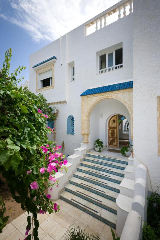 a white house with stairs leading to a door at Villa Phoenicia in Hammamet