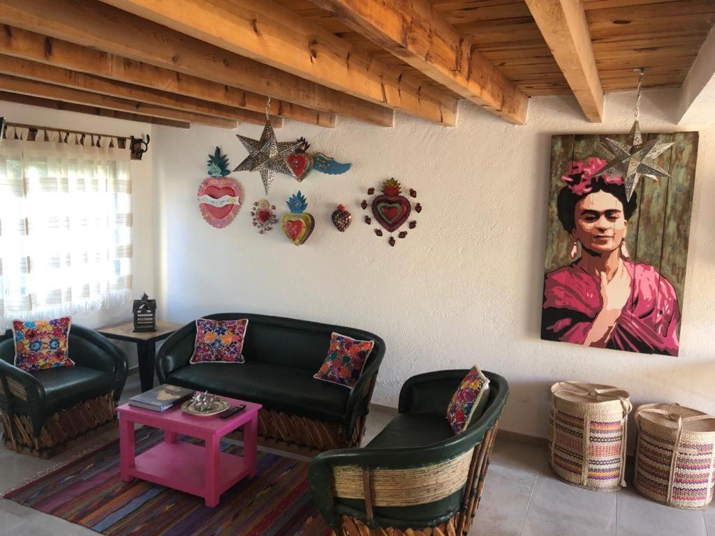 een woonkamer met een schilderij van een vrouw aan de muur bij CASA FRIDA, Casa p/6 pax Centro Tequisquiapan in Tequisquiapan