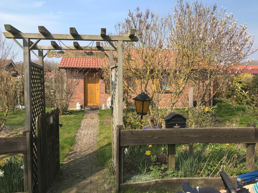 uma cerca de madeira com um portão num jardim em Wohlfühloase Villa Sunshine an weißem Sandstrand em Dahme