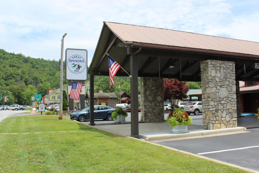 un distributore di benzina con due bandiere americane e un cartello di Great Smokies Inn - Cherokee a Cherokee