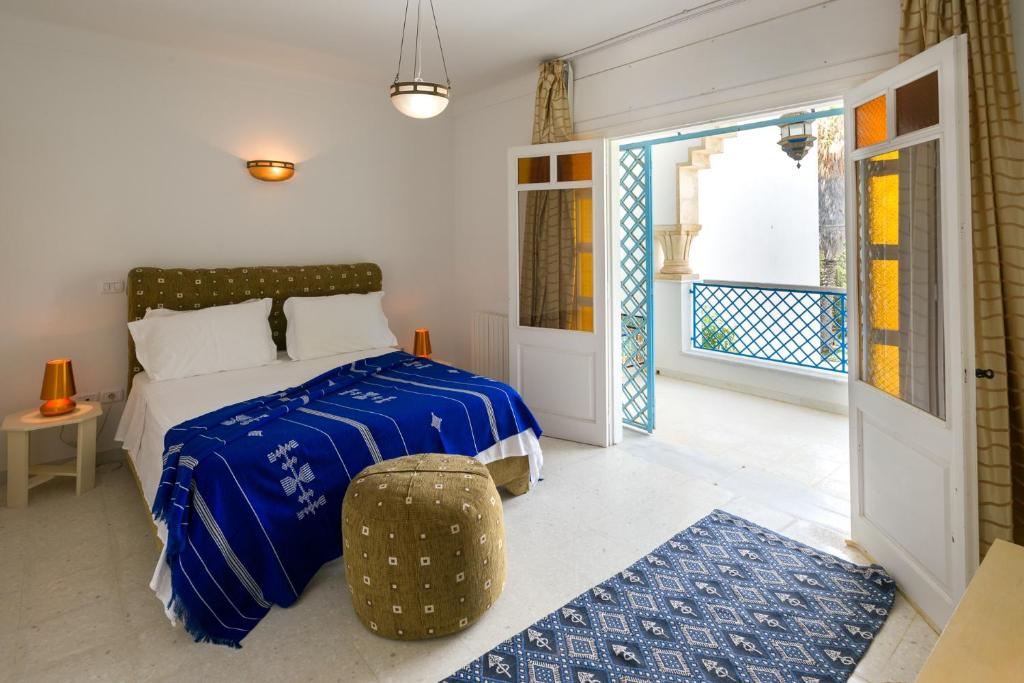 a bedroom with a bed with a blue comforter at Villa Phoenicia in Hammamet