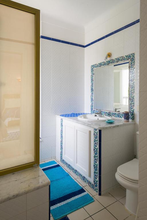 a bathroom with a sink and a toilet and a mirror at Villa Phoenicia in Hammamet
