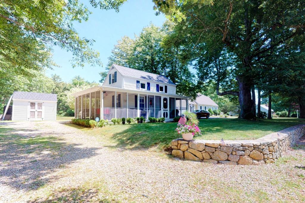 a white house with a stone wall at Wendell K. Backus House in Cotuit