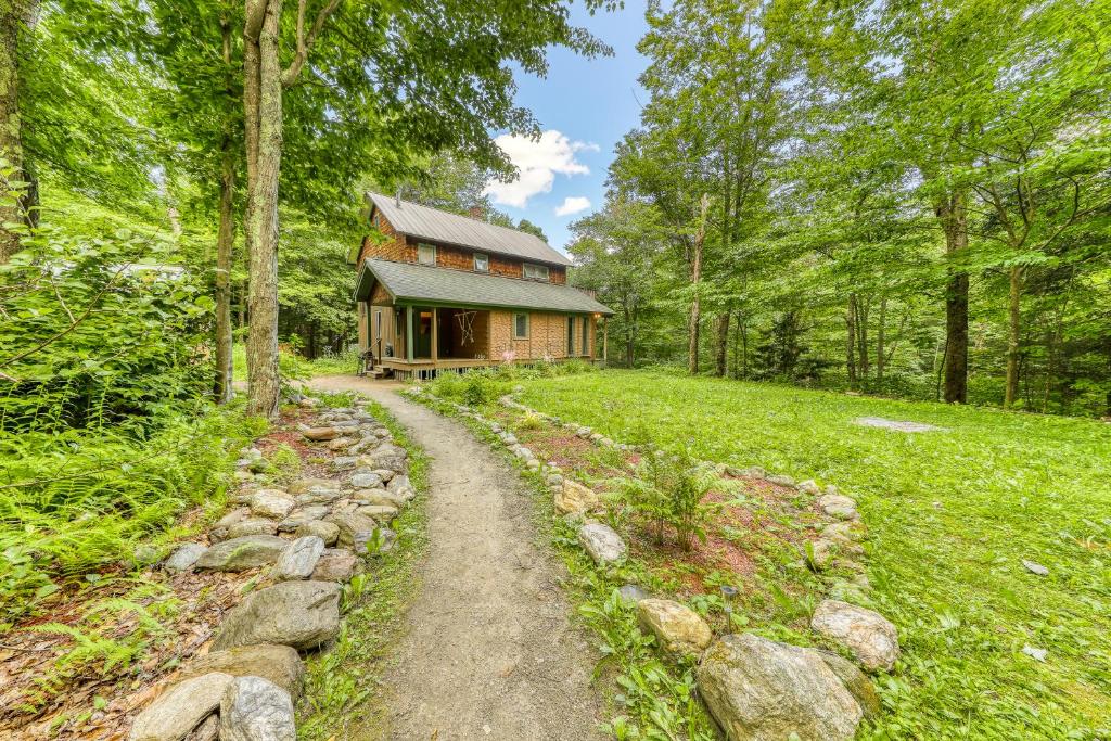eine Blockhütte im Wald mit einem Weg, der dorthin führt in der Unterkunft Birch Hollow Cottage in Warren