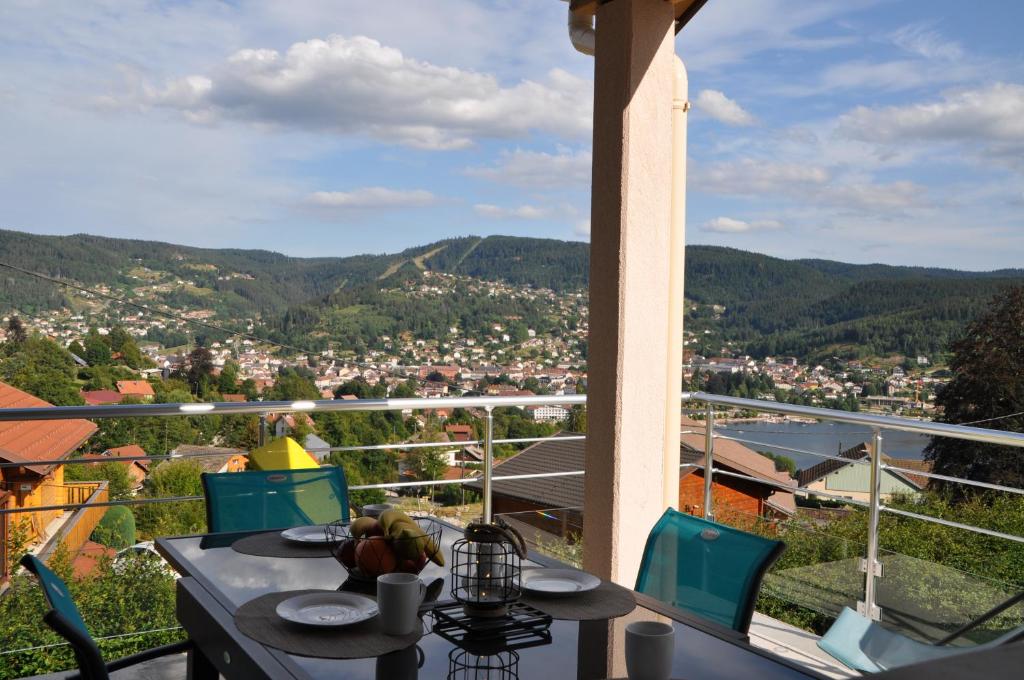 a table and chairs with a view of a city at le bleu du lac Sauna et Spa in Gérardmer