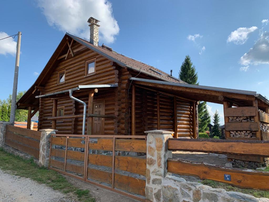 una cabaña de madera con una valla delante en Srub Bublava 155 en Bublava