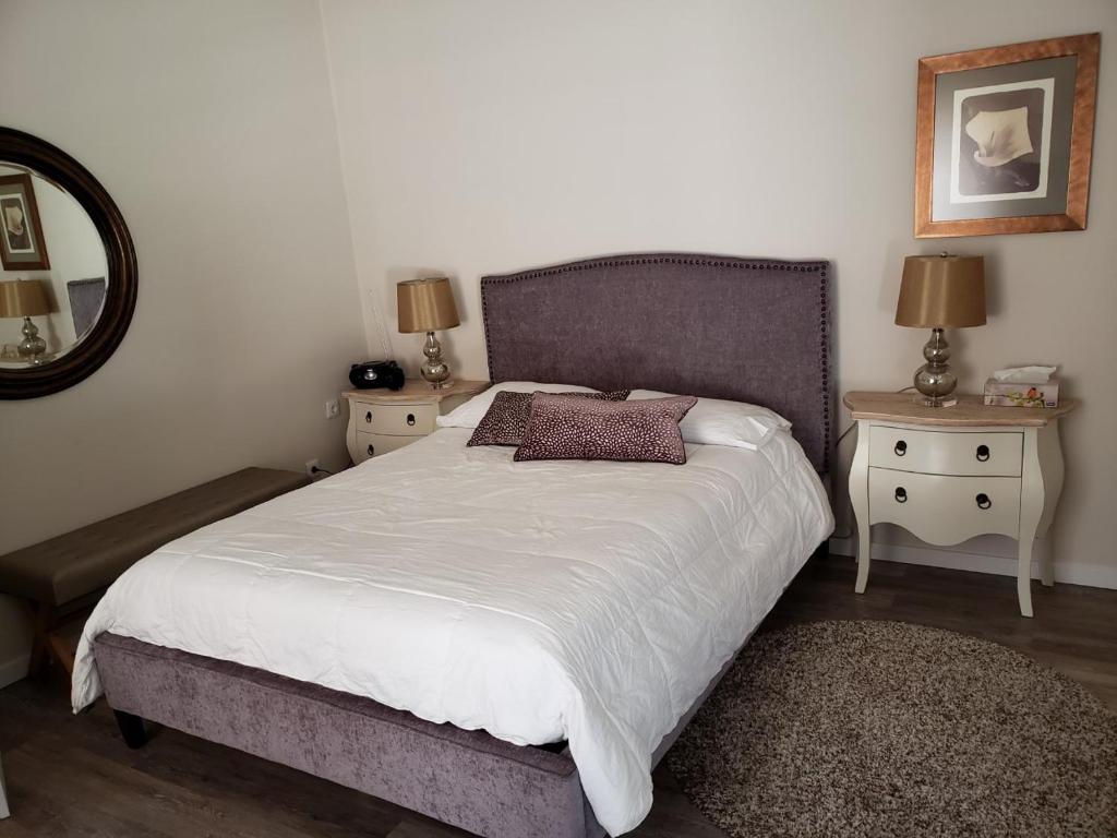 een slaapkamer met een groot bed met 2 nachtkastjes bij Areia Beach Guest House in Vila do Conde