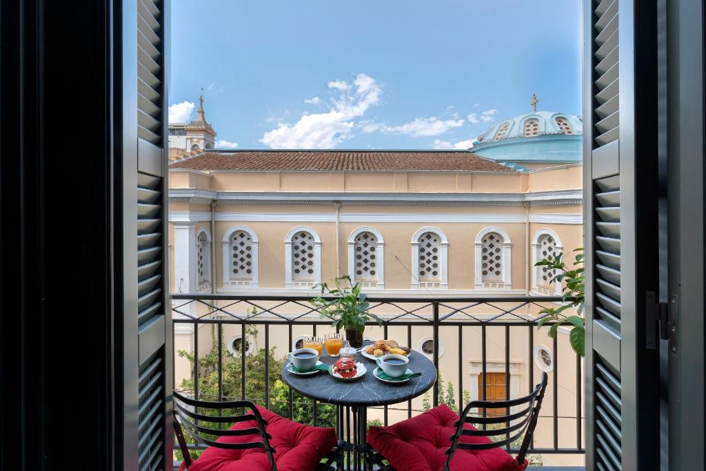 a balcony with a table and chairs and a building at Noma Hotel in Athens