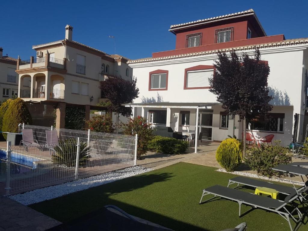 a house with a lawn in front of a building at The Red House in Alhendín