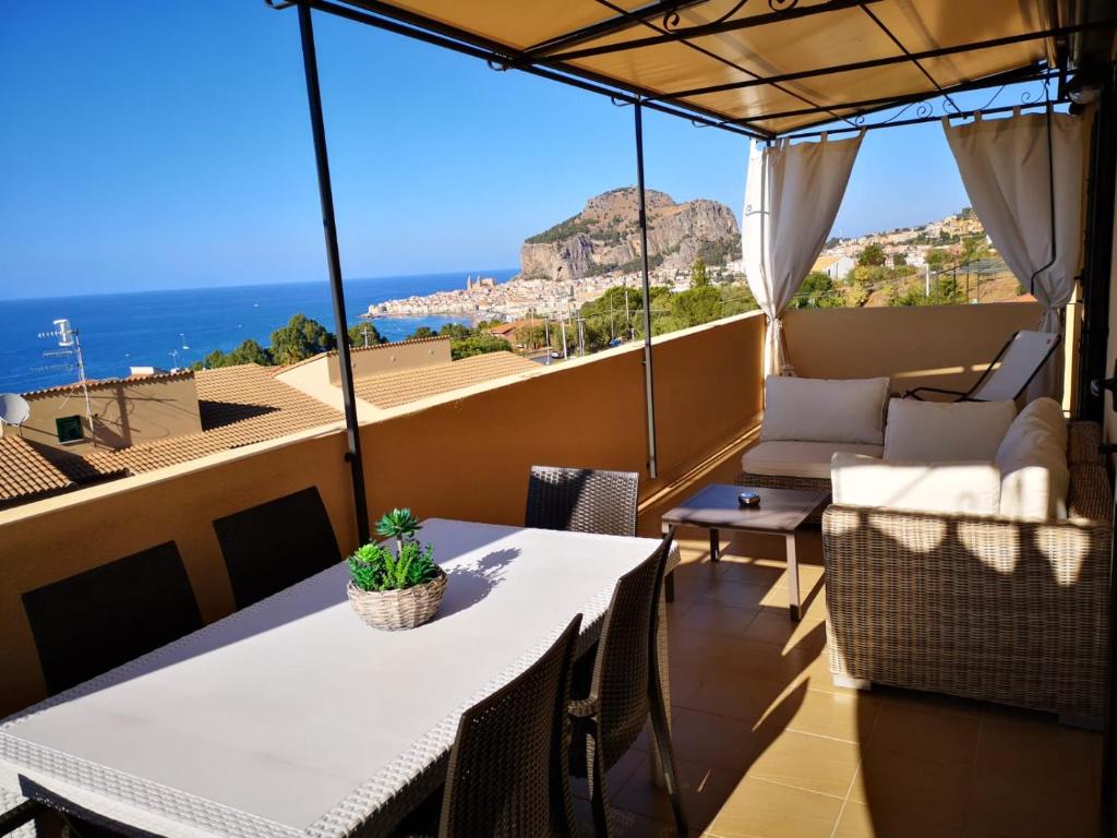 een balkon met een tafel en stoelen en uitzicht op de oceaan bij Bianco di Mare in Cefalù