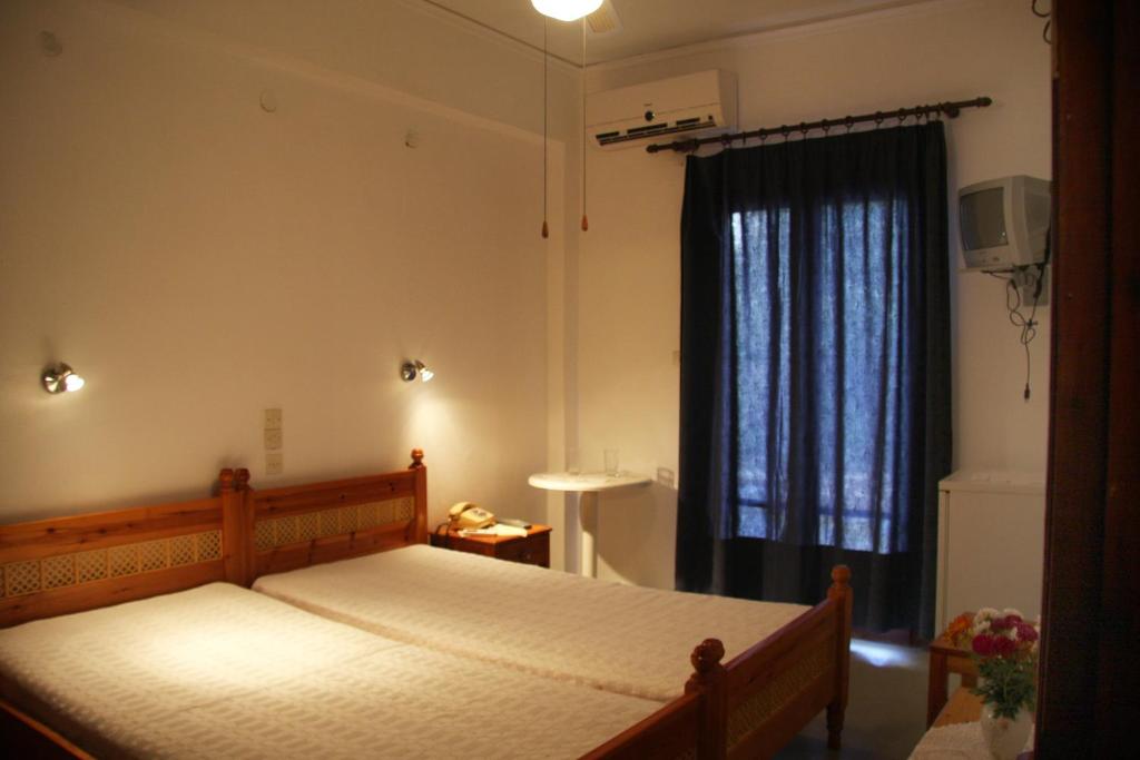 Un dormitorio con una cama grande y una ventana en Hotel Rena, en Agios Kirykos