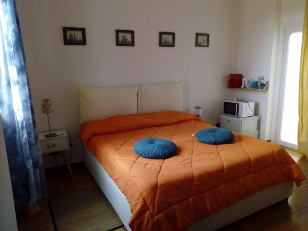 a bedroom with a bed with blue pillows on it at Camera con vista in San Lorenzo al Mare