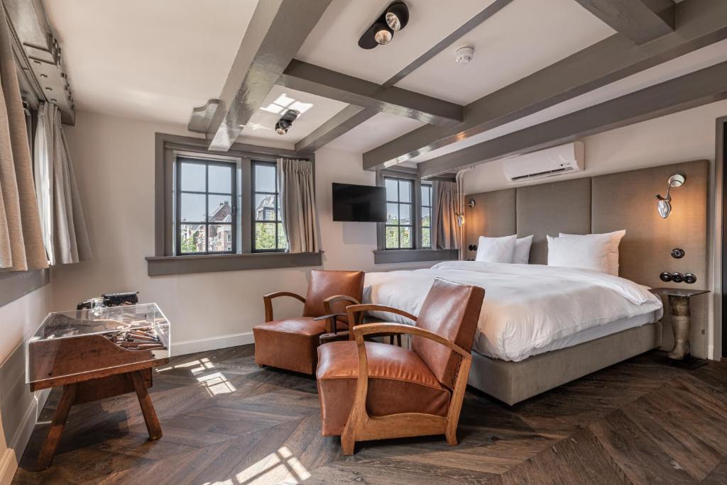 een slaapkamer met een bed, een bureau en een stoel bij Boutique Hotel The Craftsmen in Amsterdam