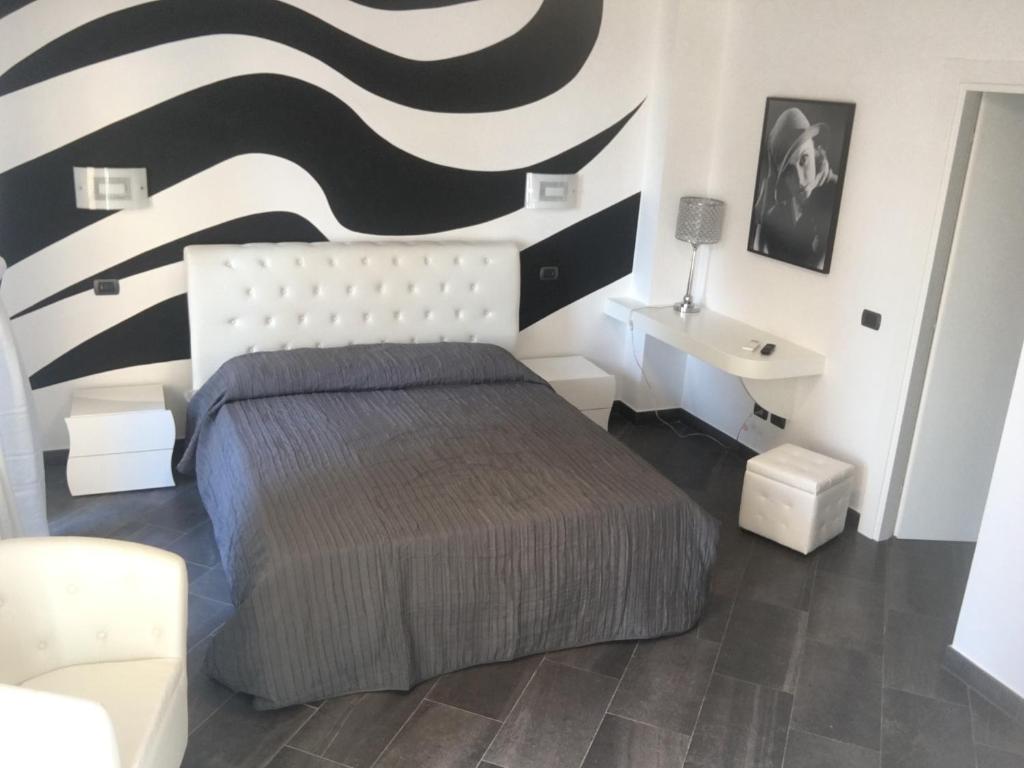 een slaapkamer met een bed en een zwart-witte muur bij Le Divine di via Olivieri - Reception Via XXV Aprile 5 in Levanto