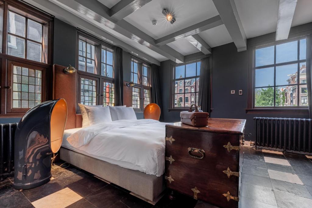 een slaapkamer met een groot bed en ramen bij Boutique Hotel The Craftsmen in Amsterdam