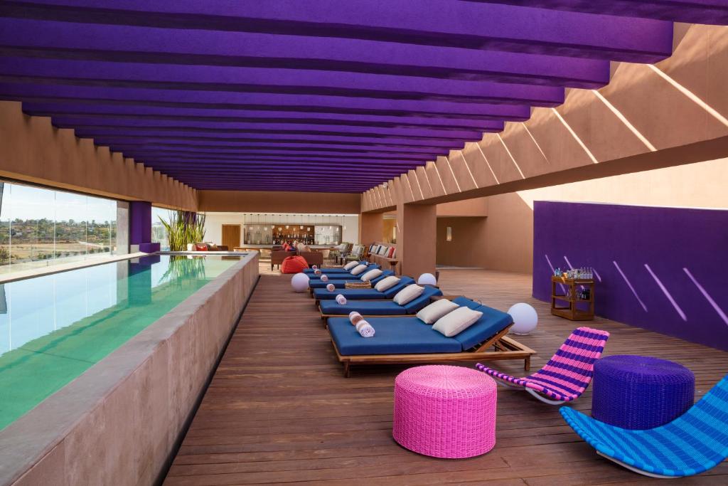 Hyatt Centric Campestre Leon في ليون: حمام سباحة مع صف من كراسي صالة الكراسي ومسبح