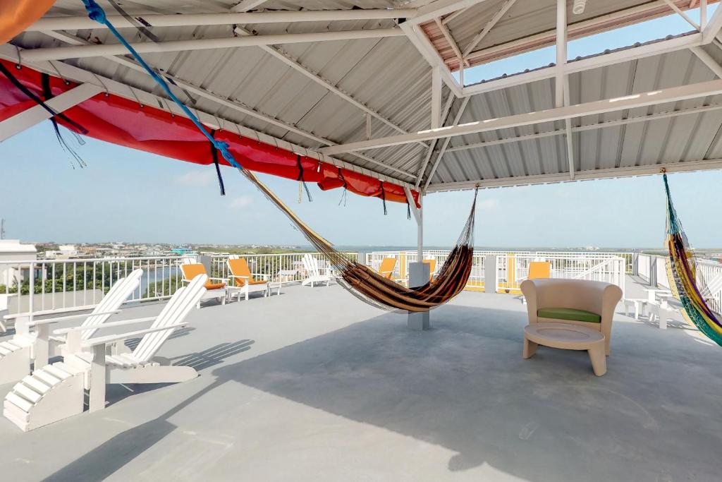 eine Terrasse mit Hängematten und Stühlen auf einem Dach in der Unterkunft Honey Camp #1 at Laguna Suite -Gold Standard Certified in San Pedro