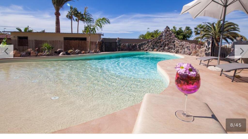 een glas wijn naast een zwembad bij Paraiso villas in Playa Paraiso