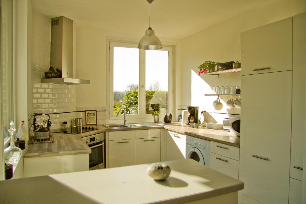 a white kitchen with a sink and a window at Villa des Groseilliers Spa Practice golf moutons in Loison-sur-Créquoise