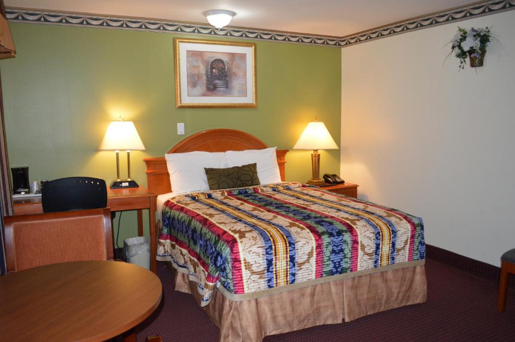Lincoln Motel في Sturgeon Falls: غرفة الفندق بسرير وطاولة