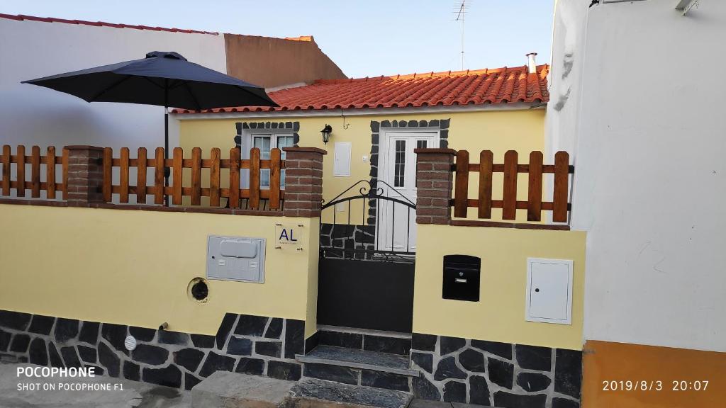 un edificio giallo con un ombrellone sul balcone di Casa O Chaparrinho a Monsaraz