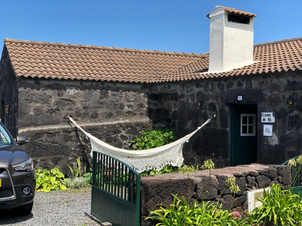 een huis met een hangmat buiten bij Casa de Lá in Prainha de Cima