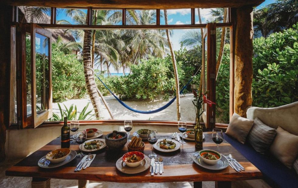 a table with food on it in front of a window at Palms house in Tulum