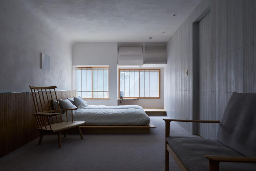 a bedroom with a bed and a chair and a couch at 滔々 御崎 二階の宿 toutou Onzaki Nikai no Yado in Kurashiki