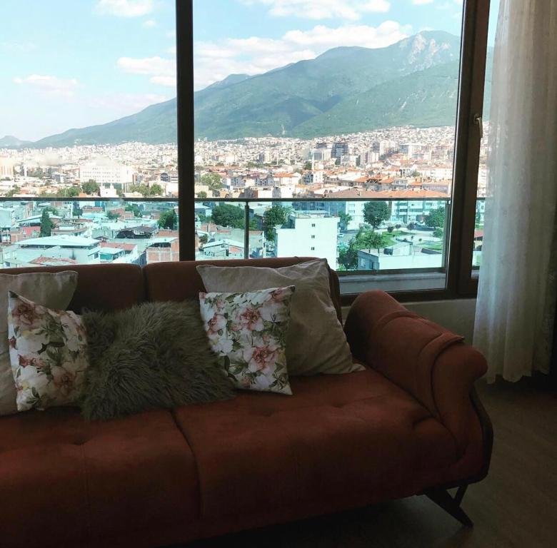 a couch in a living room with a large window at Mountains view in Bursa